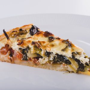 Odrezan kos Quiche polnjen z zelenjavo in sirom