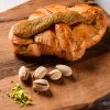 Rogljič pistacija - croissant au pistache na leseni podlagi
