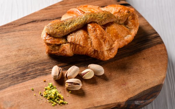 Rogljič pistacija - croissant au pistache na leseni podlagi